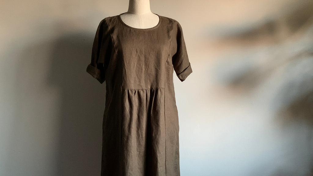 photo of a mannequin wearing a Pekho linen dress on a background of shadows