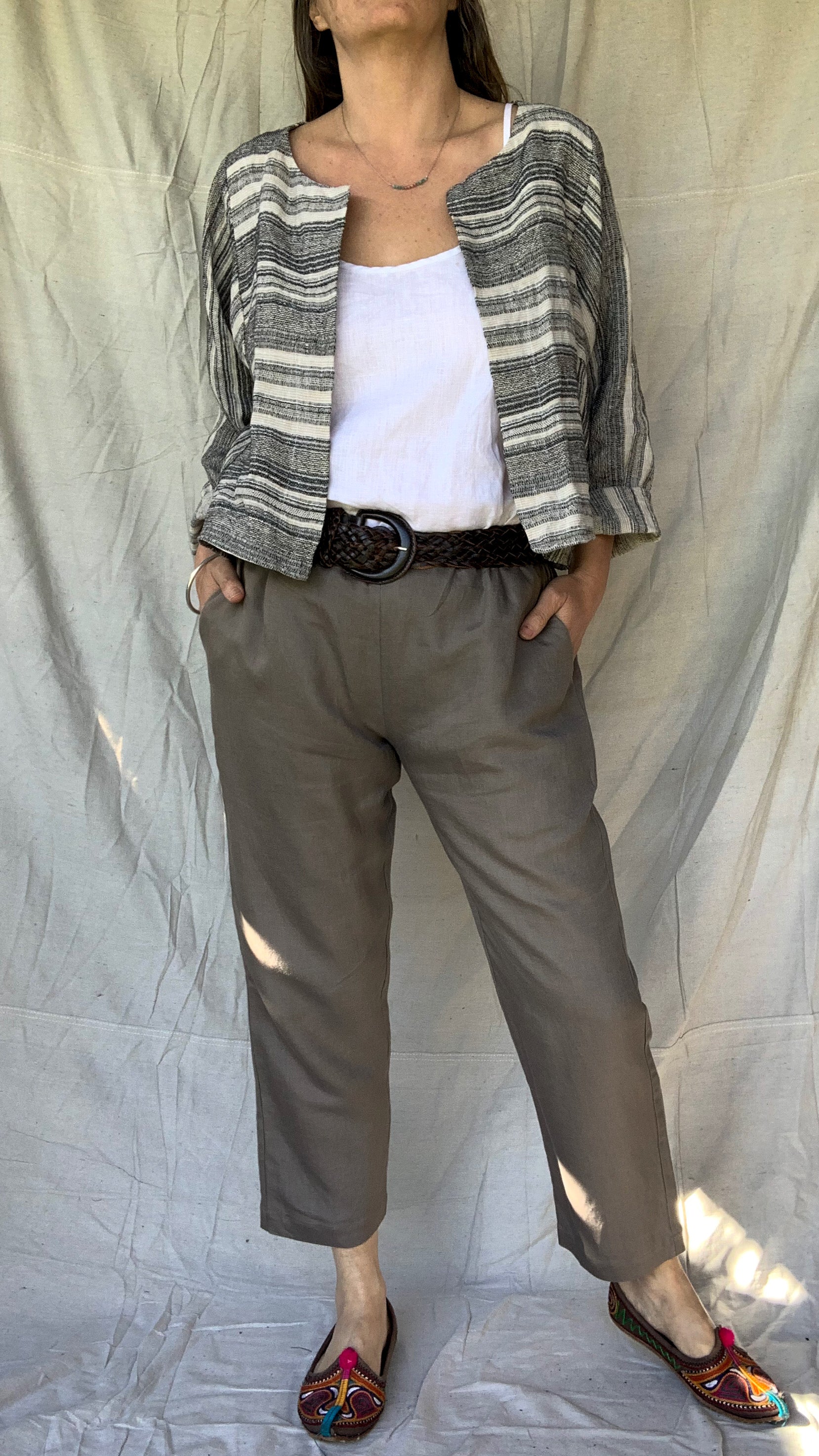 Casual linen pant with a slight tapered leg, elasticated waist and pockets worn with a white linen top and a soft linen jacket in black and natural stripe. Worn with a belt.